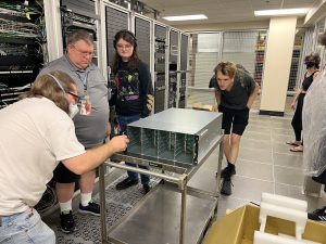 Four cats in the data center looking intently at a box